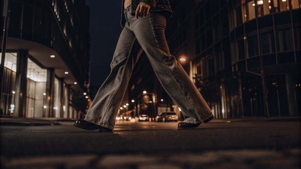 A stylish person on a city street in early 2025, wearing trendy low-rise baggy jeans.