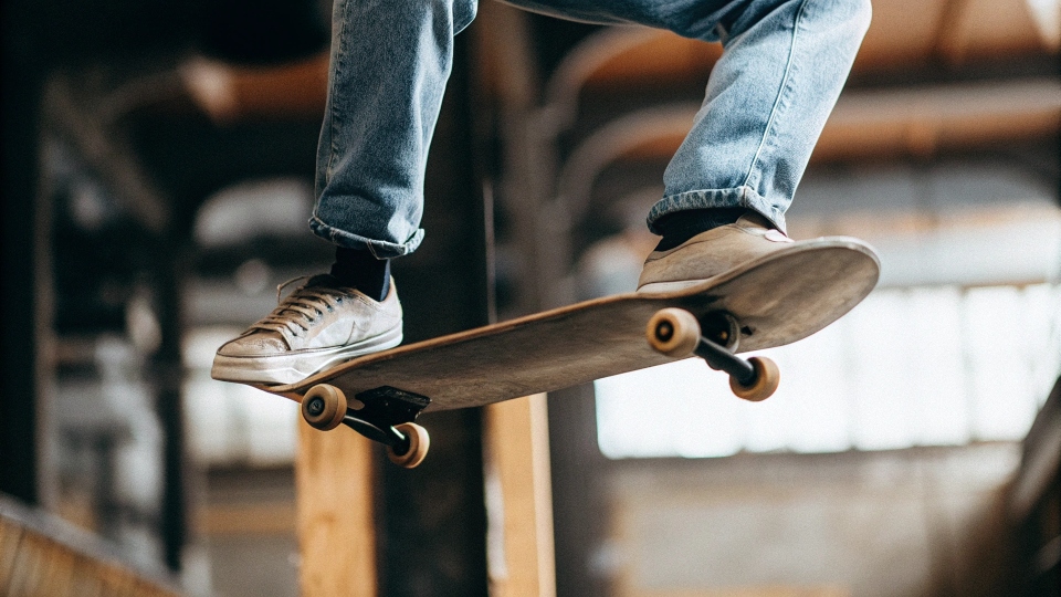 A skateboarder in mid-air wearing a pair of durable-looking Nike SB blue jeans