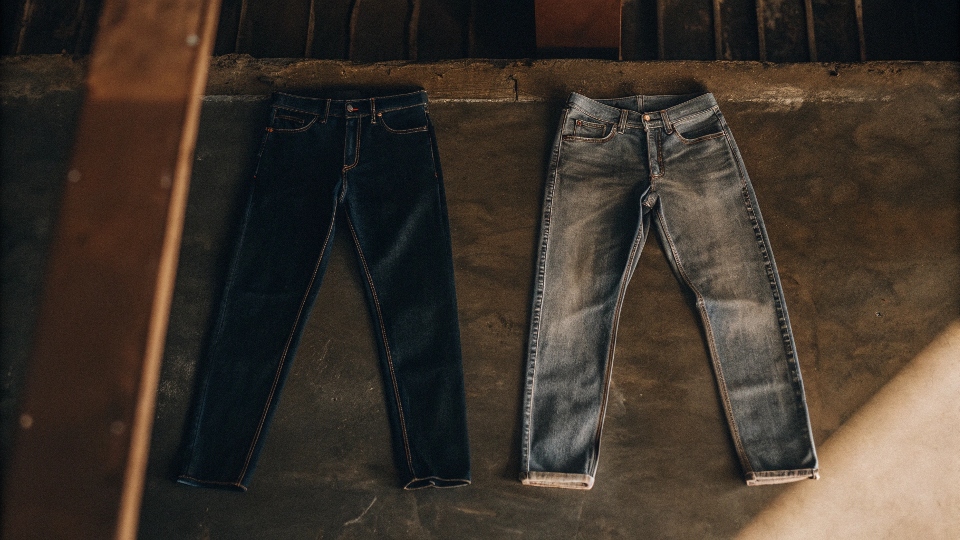 A men's jean and a women's jean laid flat side-by-side to show the difference in the hip curve