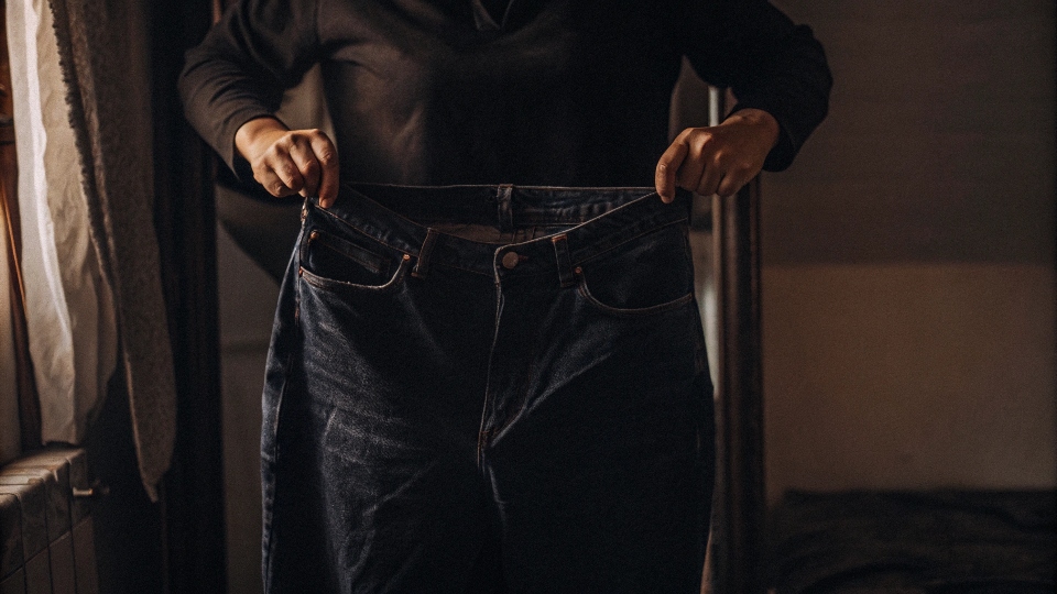 Jeans Sagging and Falling Down A person holding up the loose waistband of their sagging jeans