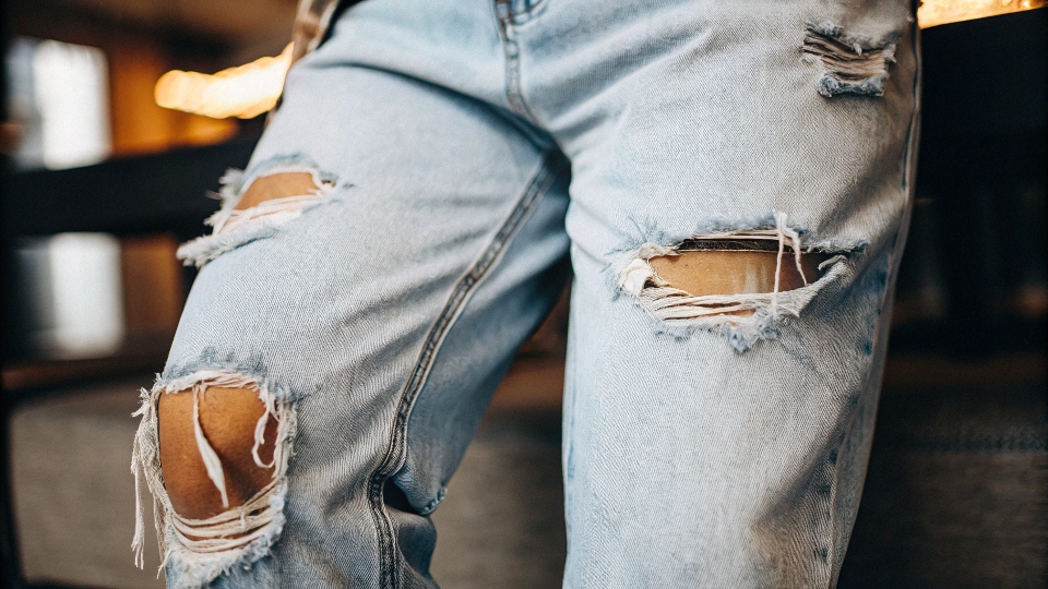 Jeans Damaged by Bleach A pair of jeans with large holes and frayed seams from severe bleach damage