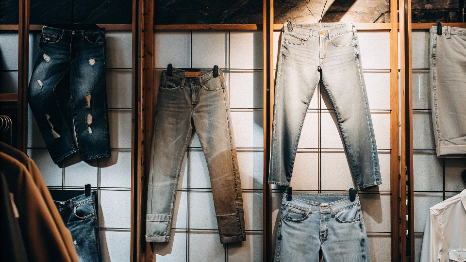 A display wall of various high-end denim brands in a premium retail store