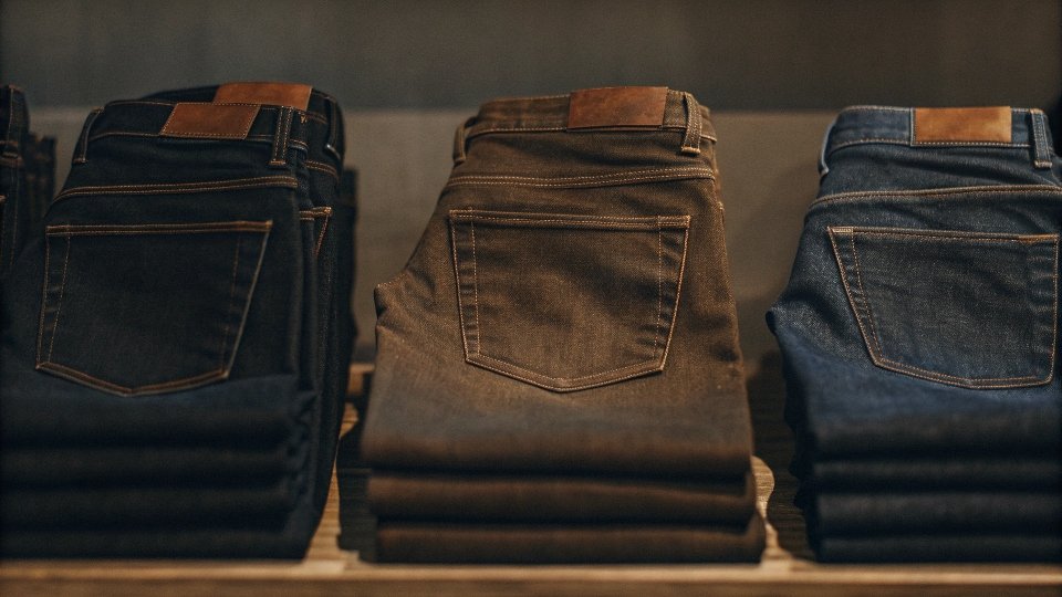 A collection of different fits of men's jeans neatly folded in a retail display