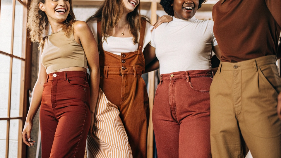 A diverse group of people happily wearing comfortable high-waisted and mid-rise jeans