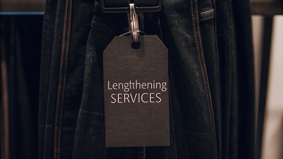 A price tag hanging from the belt loop of a pair of jeans