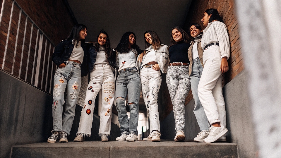 A group of high school seniors showing off their decorated senior jeans