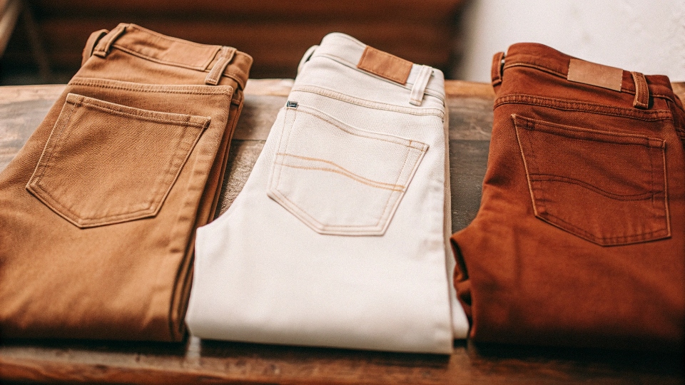 Three pairs of classic straight-leg jeans from different brands folded side-by-side