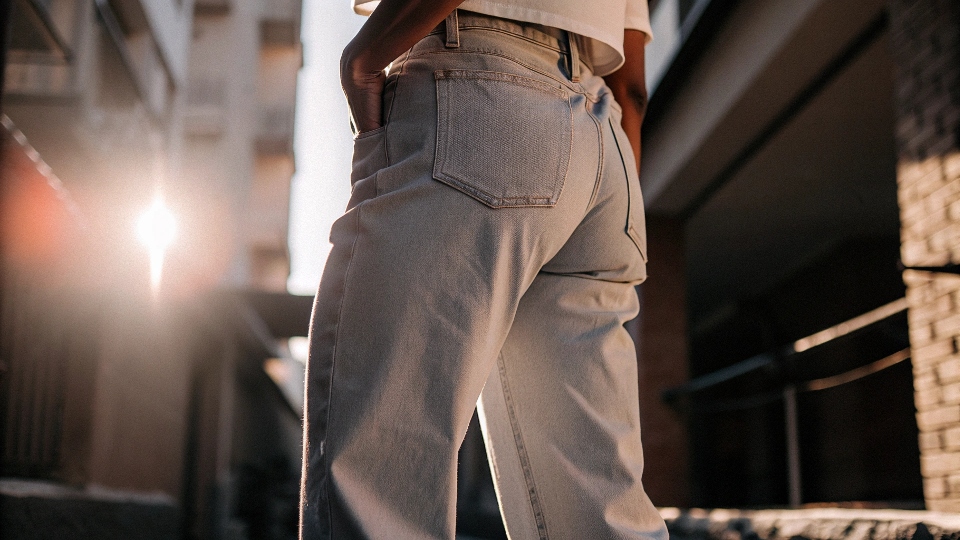A person wearing light-colored, loose-fitting jeans on a sunny day