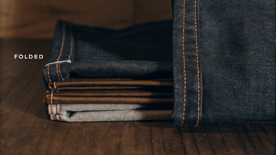 A close-up shot showing the inside of a jean hem, with the folded fabric allowance clearly visible