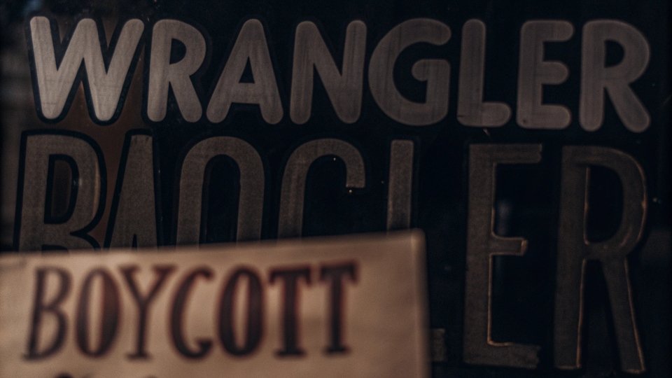 A graphic showing a brand logo with a protest sign overlay