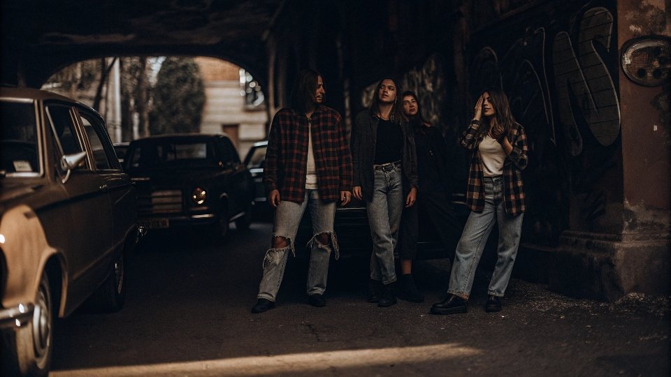 A group of teenagers in the 1990s wearing baggy, ripped jeans and flannel shirts