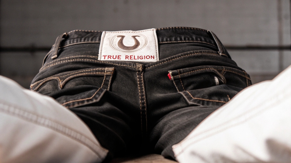 A classic pair of True Religion jeans showing the signature horseshoe logo on the back pocket