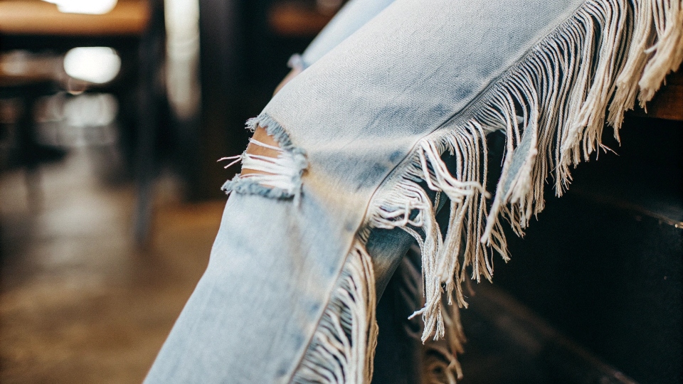 Stylish Raw Hem on Cut Jeans A close-up of a stylishly frayed raw hem on a pair of cut jeans