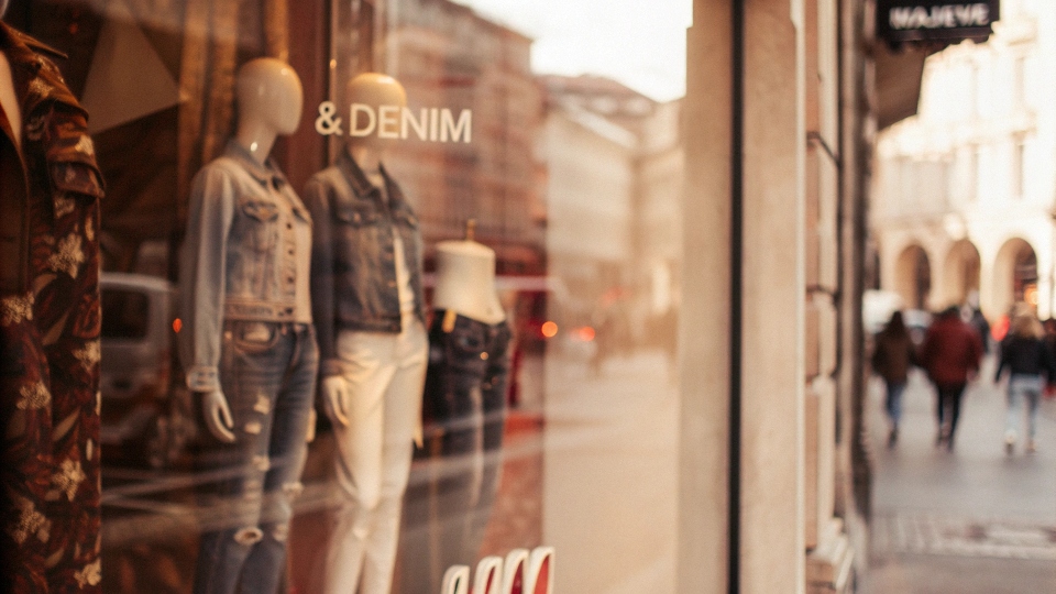 The storefront of an H&M store with "&Denim" visible in window displays