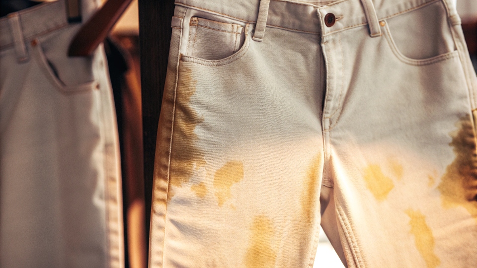 Yellowing Effect on Bleached White Jeans A close-up shot showing a yellowish, uneven tint on a pair of white jeans