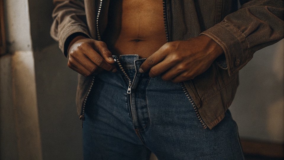 Relief from Tight Jean Stomach Ache A person unbuttoning their jeans at the waist to relieve stomach pain