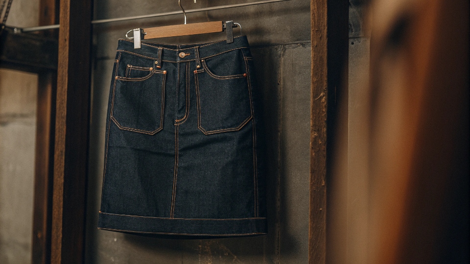 A stylish [denim skirt](https://diznewjeans.com/how-do-you-make-a-jean-skirt-from-scratch-using-fabric/)[^1] made from a pair of upcycled jeans hanging on a wall