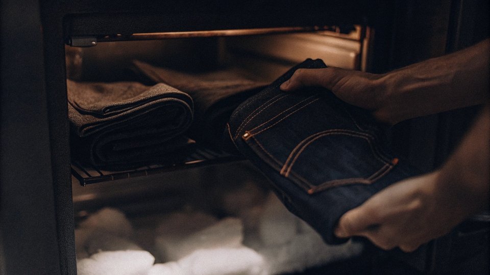 A pair of Levi's jeans being placed into a freezer