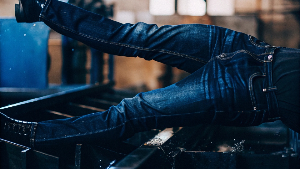 Promotional Video of Jean Production A dramatic, professional video still of jeans tumbling in an industrial washing machine.