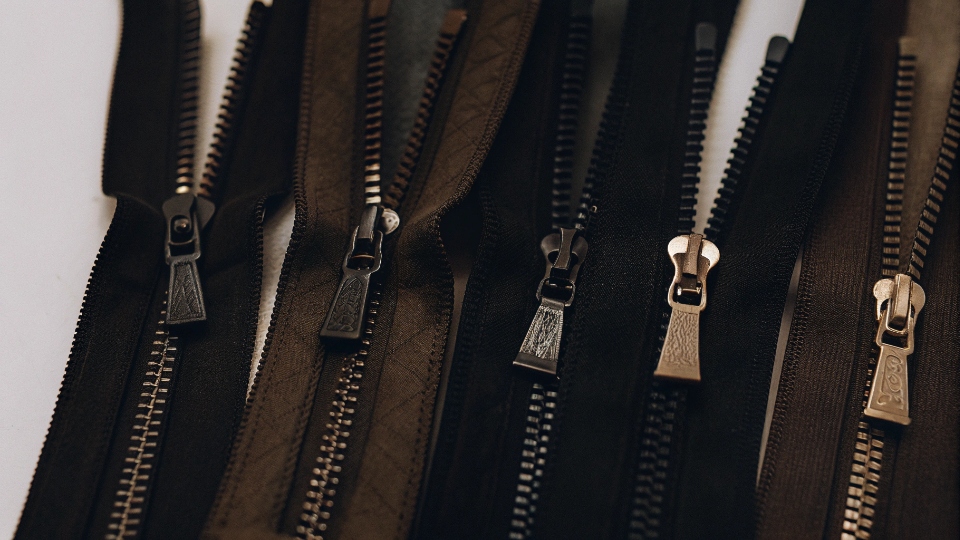 Custom Metal, Plastic, and Two-Tone Zippers A collection of custom zippers, including two-tone options and some with branded logo pullers