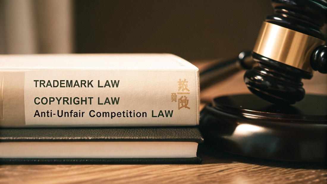 Legal Frameworks for IP Protection in China A gavel and a law book with Chinese characters on the cover, symbolizing legal IP protection in China.