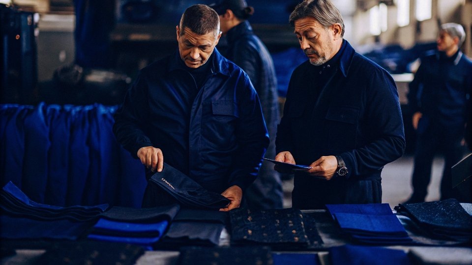 Choosing a Custom Streetwear Manufacturer A streetwear designer looking at fabric swatches with a factory manager.