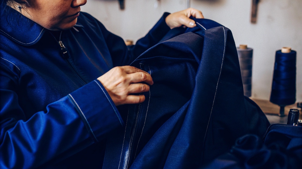 How to Find Good Quality Jeans A person inspecting the inseam stitching of a pair of jeans with a magnifying glass.