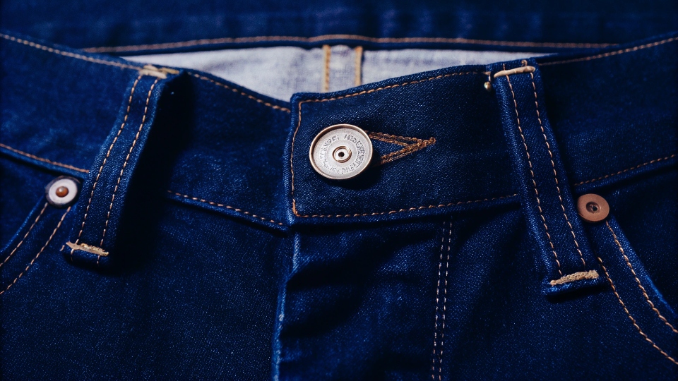 Men's Button Fly Jeans Brands A close-up shot of a classic denim button fly on a pair of men's jeans.