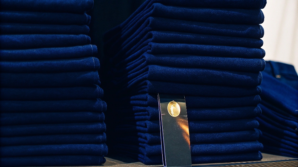 Factory Loyalty Incentives and Rebates A gold partner loyalty card next to a stack of jeans.