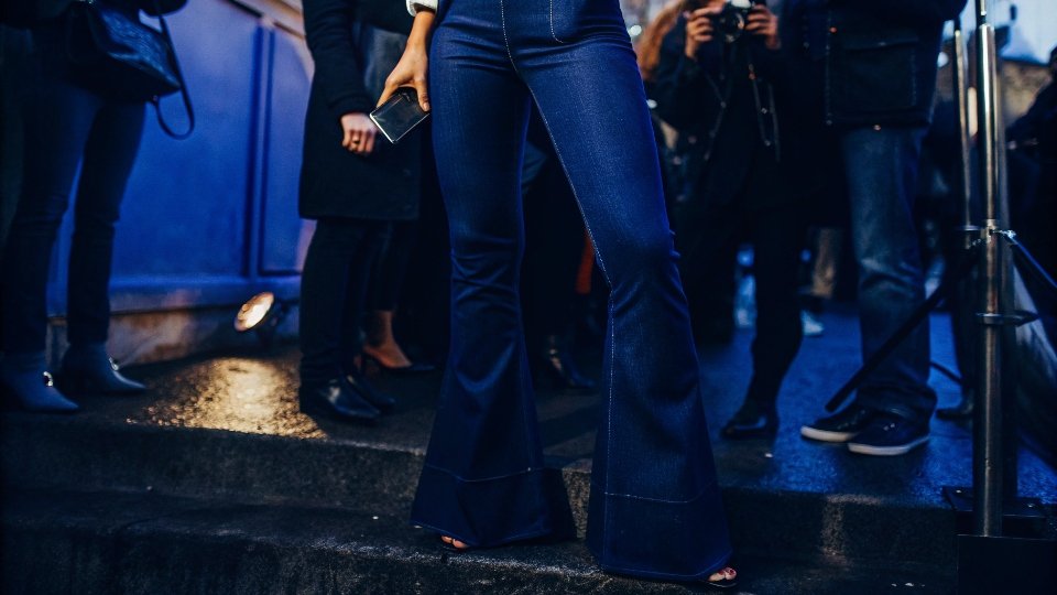 Modern Flare Jeans in Contemporary Fashion A stylish street-style photo from a recent fashion week, featuring a person wearing a modern, elegant pair of flare jeans.