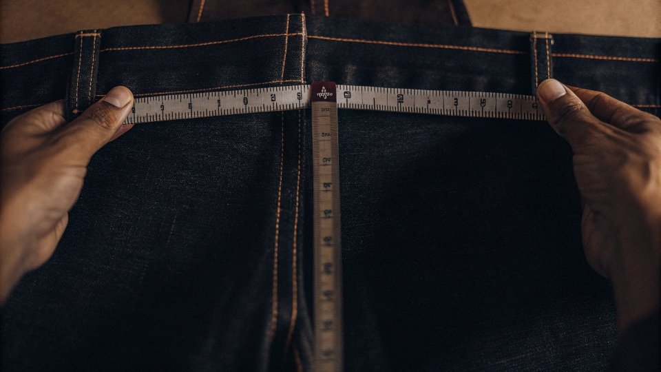 Measuring Stitches Per Inch on Jeans A ruler held up to a denim seam, showing 11 stitches within one inch