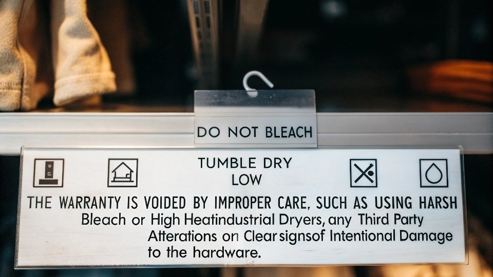 Conditions that Void Hardware Warranty A laundry care instruction tag with icons for "Do Not Bleach" and "Tumble Dry Low" clearly visible.