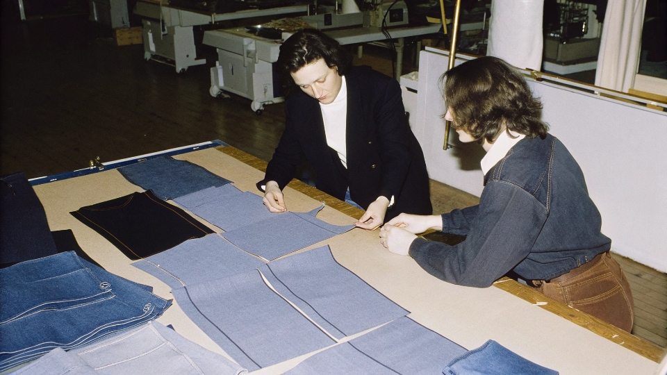 Negotiating MOQs for Custom Jeans A designer negotiating with a factory manager over a table with jean samples