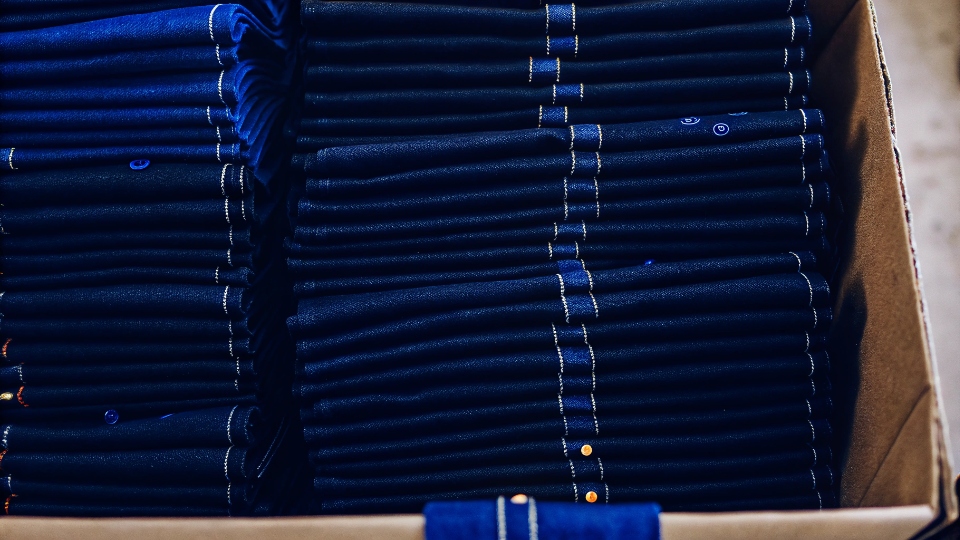 Returning Unused Denim Fabric Off-Cuts Neatly folded and labeled denim off-cuts stacked in a box, ready for shipping.