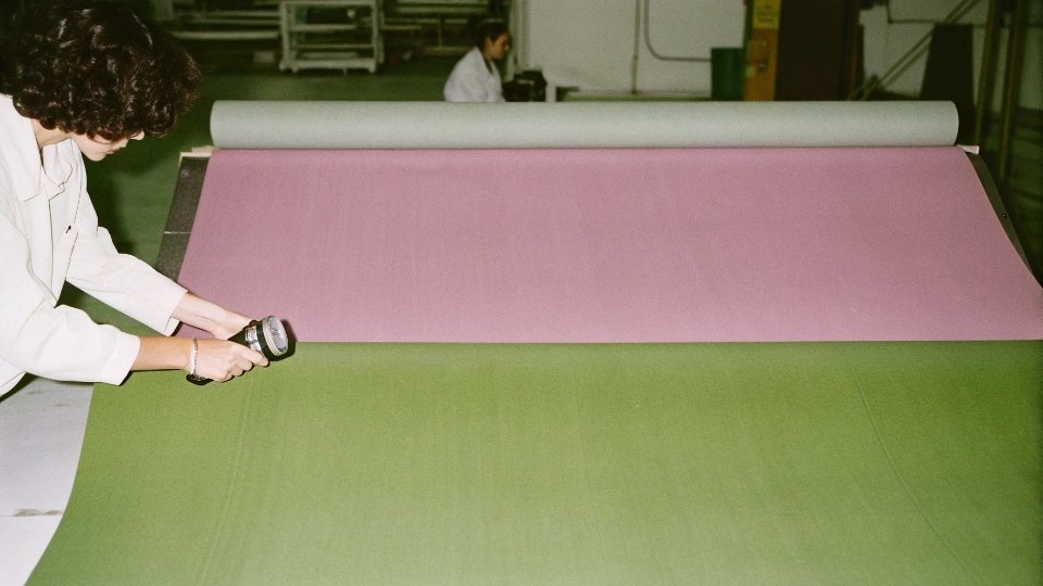 Ensuring Denim Fabric Uniformity Between Lots A quality inspector using a spectrophotometer to compare color consistency between two rolls of denim