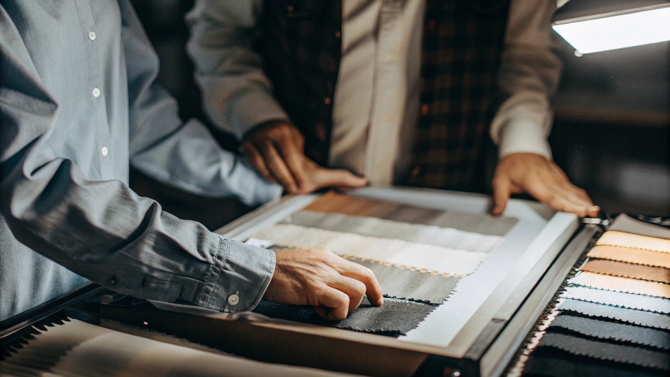 Maintaining Batch-to-Batch Color Consistency A QC inspector comparing newly dyed fabric against a master swatch in a light box