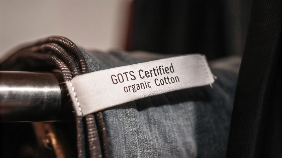 Eco-Certified Denim and Traceability A close-up of a GOTS certified organic cotton label sewn onto a pair of jeans