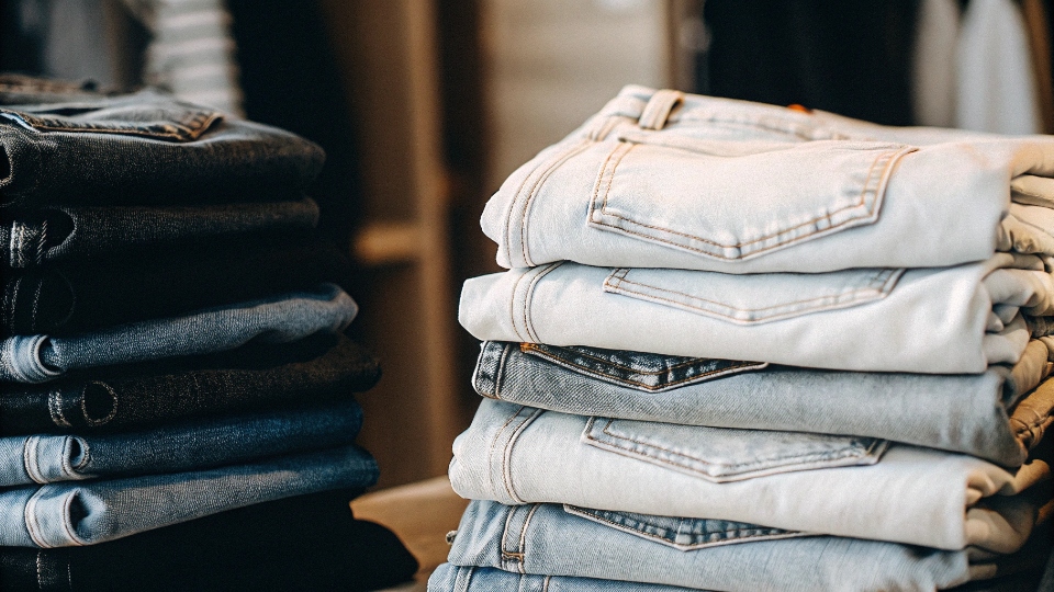 Bundled Multi-Style Jean Order A collection of different jean styles and washes neatly folded together, representing a bundled order.