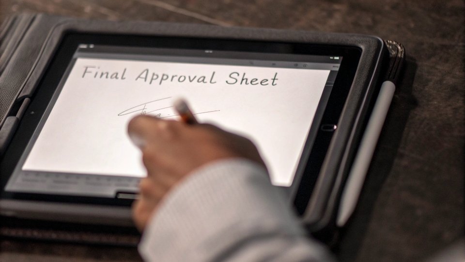 Digital Signature for Final Tech Pack Approval A person digitally signing a document on a tablet, with the text "Final Approval Sheet" visible on the screen.