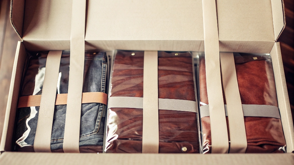 Protective Packaging for Jeans During Transit A neatly packed master carton of jeans being sealed, showing the protective layers inside