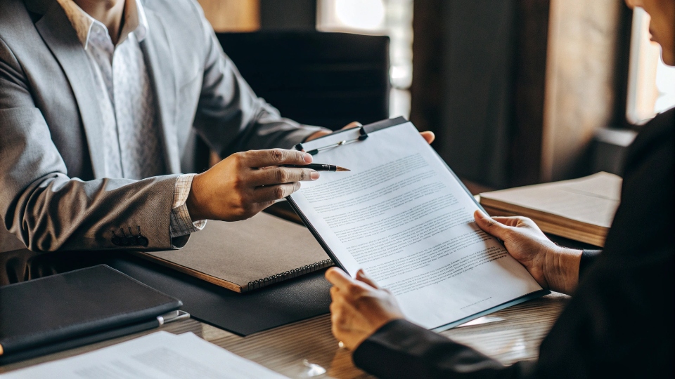 Purchasing Additional Cargo Insurance Through Your Factory An insurance agent presenting an additional insurance policy document to a client.