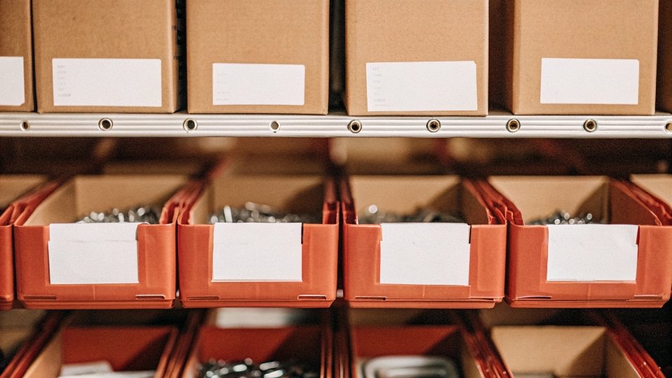 Secure Storage of Custom Molds A clean, organized warehouse shelf with labeled boxes containing hardware molds.