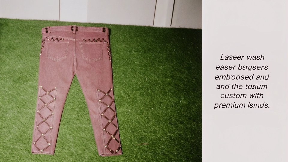 Close-up of a pair of jeans showing a complex laser wash and custom embossed rivets