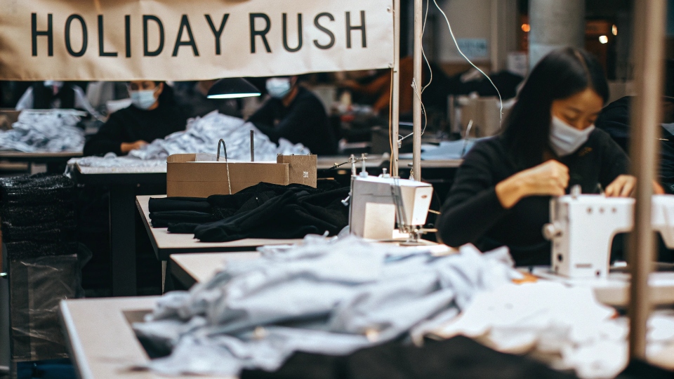 Peak Holiday Season Jean Production A bustling but organized jeans factory floor with workers focused on sewing, with banners showing 'Holiday Rush'