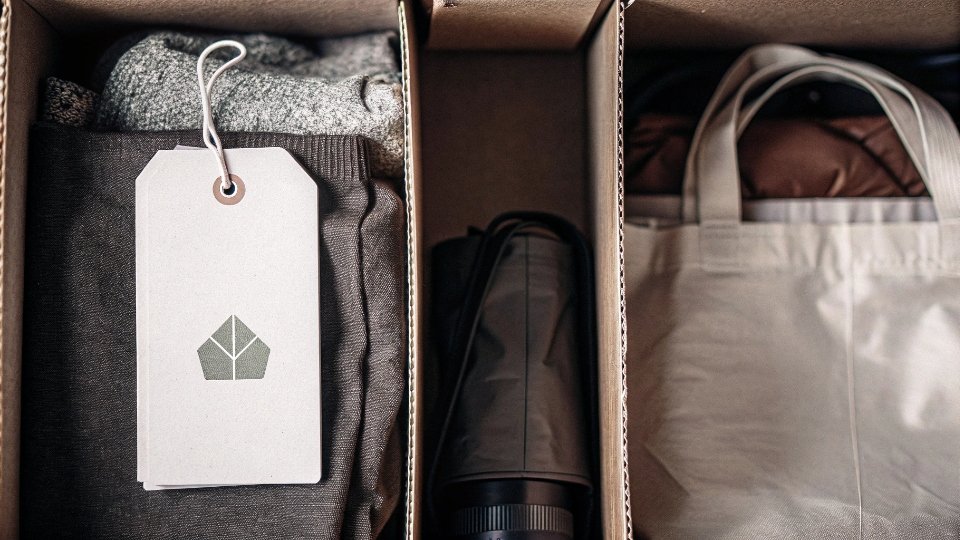 Eco-Friendly Packaging Materials for Denim A flat lay of eco-friendly packaging: recycled paper hangtag, organic cotton labels, and a PLA bag with a green leaf icon