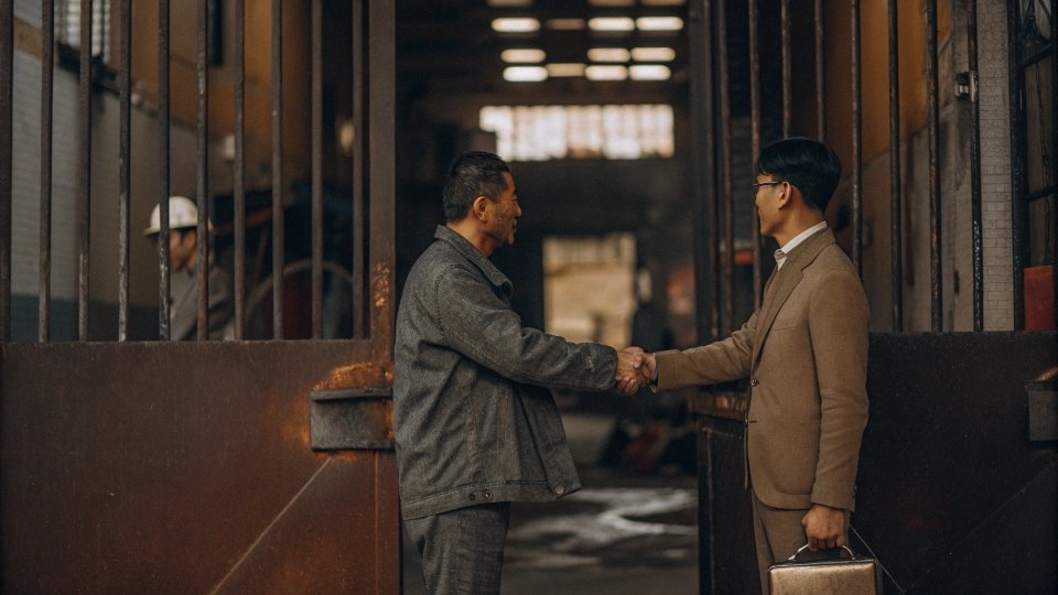 Scheduling a Factory Visit During a Trade Show A denim designer shaking hands with a factory manager at the entrance to the DiZNEW factory in Dongguan.