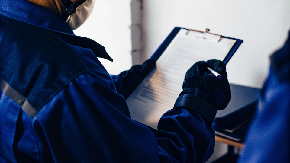 A safety officer reviewing a chemical safety data sheet on a clipboard