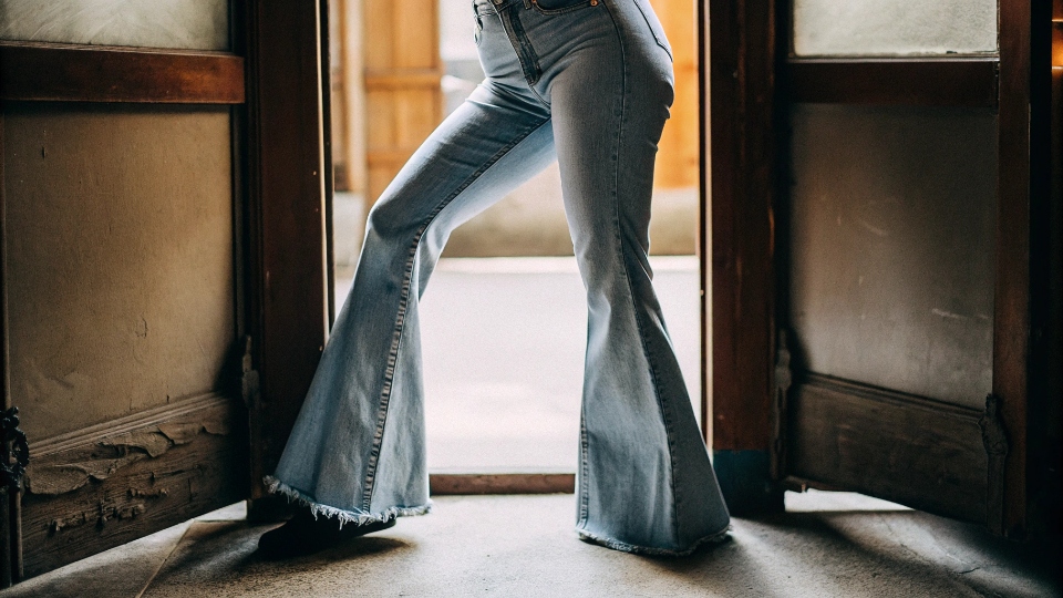 Balancing Proportions with High-Waisted Flare Jeans A stylish person with a curvy figure wearing high-waisted flare jeans, creating a long, balanced silhouette.