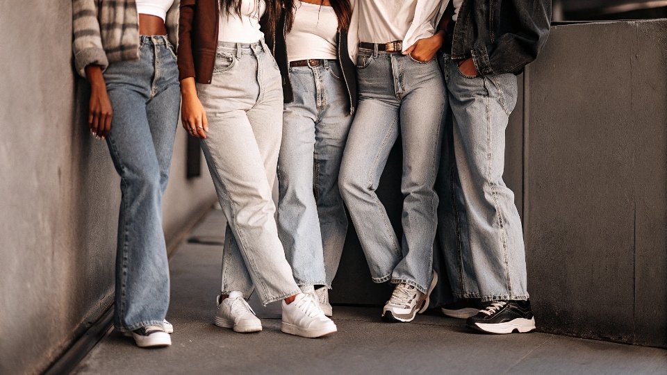 Gen Z Embracing Baggy Jeans Trend A group of young people in trendy, baggy jeans, showcasing 90s and Y2K fashion influences.
