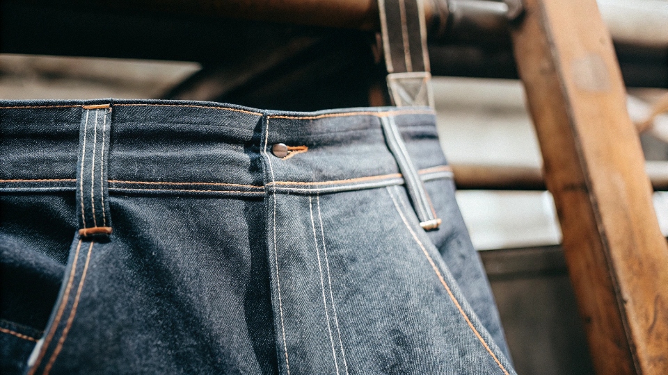 Close-up of Heavyweight Denim A close-up shot of very thick, raw heavyweight denim, highlighting the deep indigo color and rigid texture.